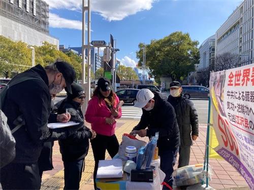 '图3:过往市民驻足了解真相,有的签名声援诉江。'