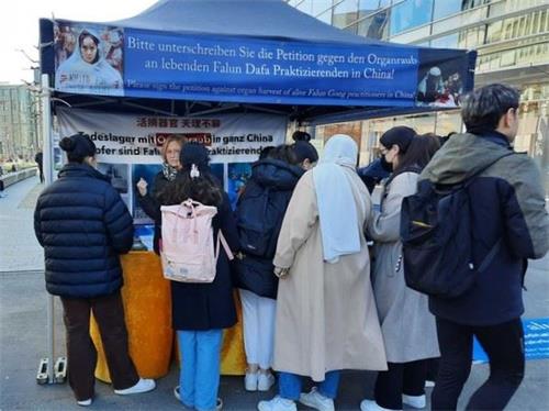 '图3:二零二二年三月五日,民众在杜塞尔多夫法轮功学员的真相点前了解真相,并为反迫害签名。'