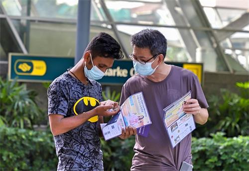 图2:一位孟加拉客工捧着学员赠送的手工小莲花,爱不释手。