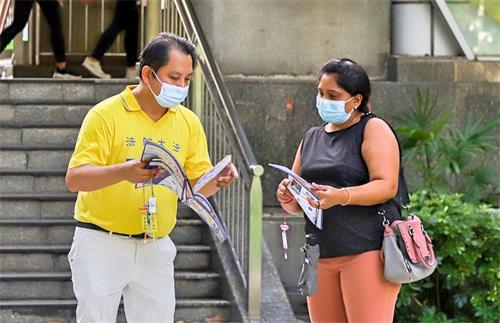 图4~6:各族裔民众驻足与学员攀谈,了解法轮功真相。