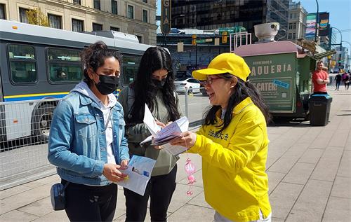 图13:来自墨西哥的比莱卡·乌阿杰(Bealaica Uaaje)正与学员攀谈,了解法轮功。