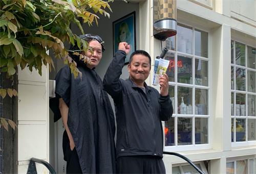 '图9:这位男士拿了介绍法轮功的真相传单,举着手表示支持。'