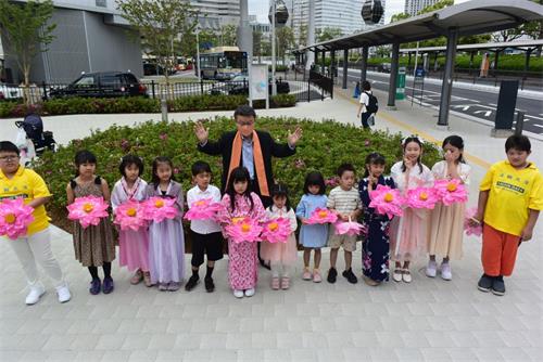 '图7:前众议院议员中津川先生前来参加庆祝大法日活动和小弟子合影'