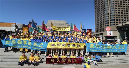 '图1:二零二二年五月七日,加拿大魁北克省部分法轮功学员在蒙特利尔市中心举行盛大游行,庆祝世界法轮大法日。图为学员们合影恭贺师父华诞。'