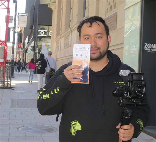 '图18:蒙特利尔市民朱利安・拉波特(Julien Lapointe)喜欢法轮大法传单上的真、善、忍三个字,“我百分百赞同!”'