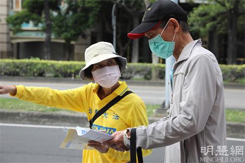 图4:法轮功学员派发资料给过往民众。