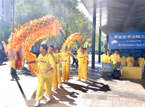 '图4~5:西澳法轮功学员在珀斯市中心步行街上以舞龙表演来庆祝法轮大法传世三十周年'