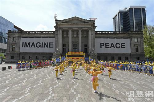 图1:五月八日,温哥华地区部分法轮功学员在温哥华市中心艺术馆北侧庆祝法轮大法弘传世界三十周年。(明慧网)