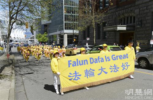 图5-11:五月八日,温哥华地区部分法轮功学员在温哥华市中心艺术馆庆祝法轮大法弘传世界三十周年,集会之后他们举行了游行活动(明慧网)
