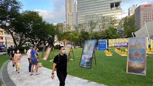'图4~6:熙来攘往的行人放慢脚步,观看拍照,聆听法轮功真相,阅读资料。'