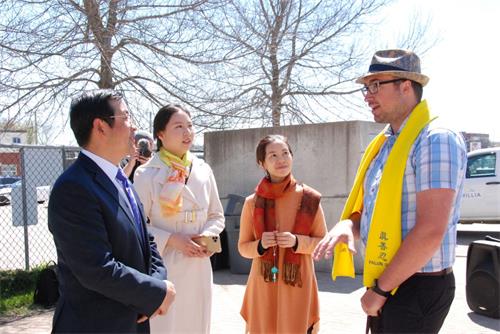 '图05:安省奥里利亚(Orilla)市议员梅森‧安斯沃斯(Mason Ainsworth)(右一)和法轮功学员交谈。'