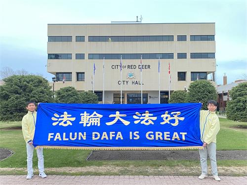 '图2:法轮功学员在红鹿市政厅外展开“法轮大法好”横幅。'