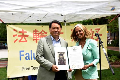 '图7:宾州州参议员克里斯汀·塔尔塔廖内(Christine M. Tartaglione)的办公室主任卡门·索萨(Carmen v Sousa)女士(右),当天来到自由钟广场,代表参议员向法轮大法学员颁发了宾州参议院庆祝世界法轮大法日的褒奖。'