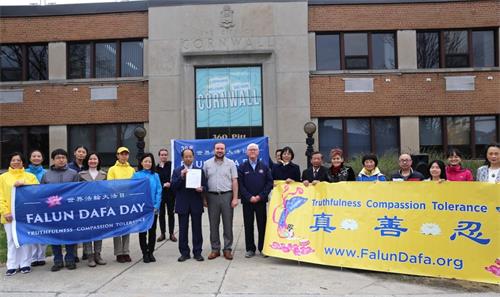 'alltogether:图说: 5月2日上午十点,安大略省康沃尔市市长格兰特(Glen G Grant)和国会议员邓肯(Eric Duncan)先生共同在康沃尔市政府前升旗,庆祝法轮大法弘传世界三十周年。图为市长、议员和部分法轮功学员合影。'
