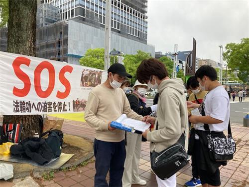 图1~2: 二零二二年五月十五日(星期日),过往市民在声援诉江的签名纸上签名时情景。