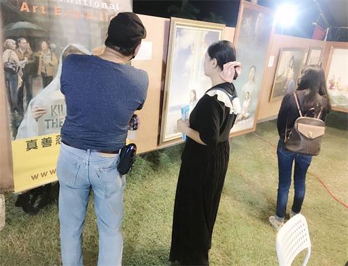 '图2、4、7:人们驻足欣赏法轮功学员的画作,了解真相'