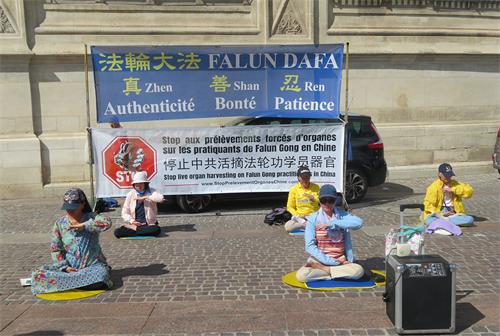 图1:二零二二年六月十一日, 法轮功学员在巴黎市中心的夏特蕾街区演示法轮功功法。