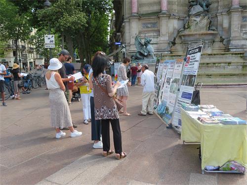 图9:二零二二年六月十九日,在巴黎圣米歇尔广场(Place Saint-Michel),人们观看展板,了解法轮功真相,签名支持制止迫害。