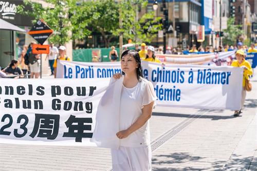 '图9:蒙特利尔法轮功学员朱颖参加反迫害游行。'