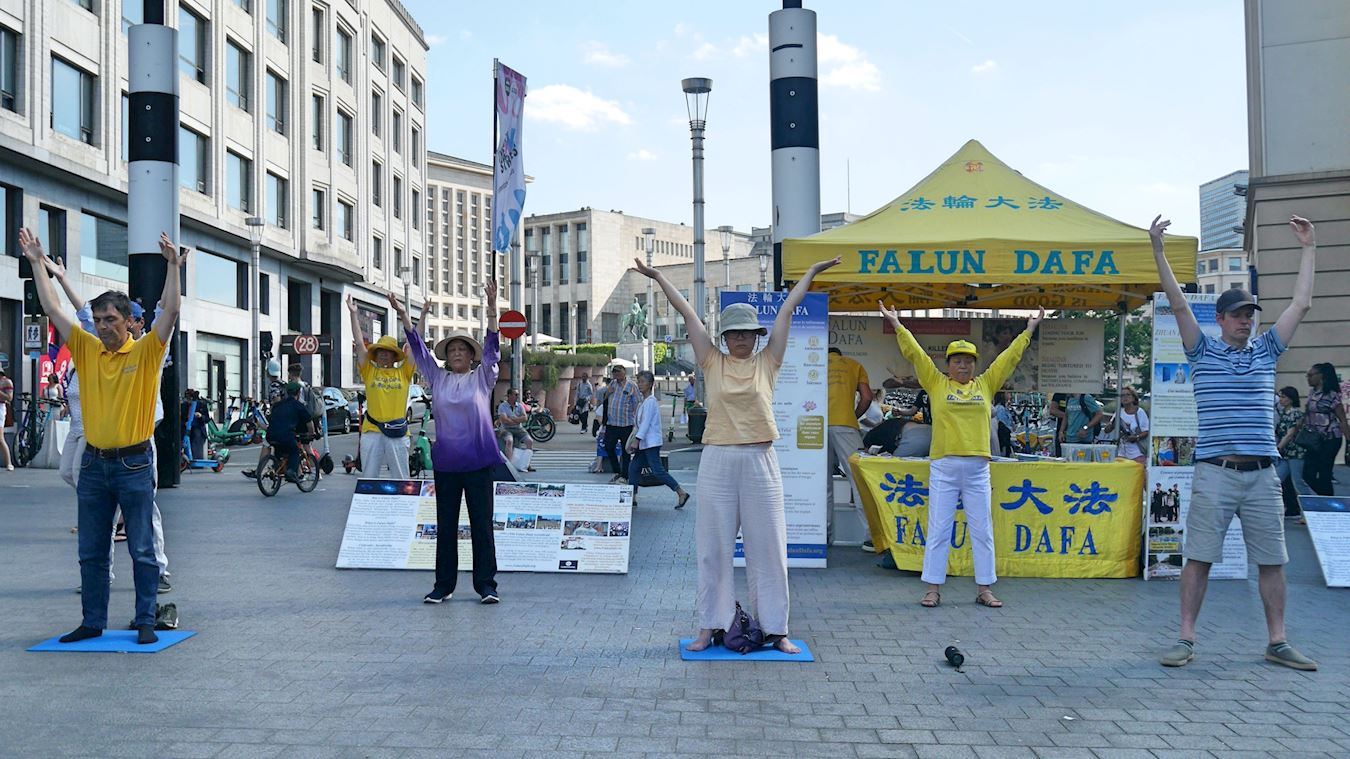 '图1:二零二二年七月十六日,部份比利时学员在布鲁塞尔欧洲广场(Square de I、Europe)举办信息日,传播法轮功的真相。图为法轮功学员演示功法。'