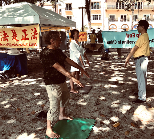 图5:对功法感兴趣的民众当场和学员学炼法轮功