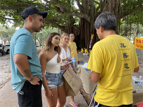 图8:民众前来了解法轮功真相。从左到右 费尔南多·科尔特斯(Fernando Cortez)、泰勒·麦金利(Taylor McKinley)、西蒙娜·萨帕塔(Simona Zapata)。