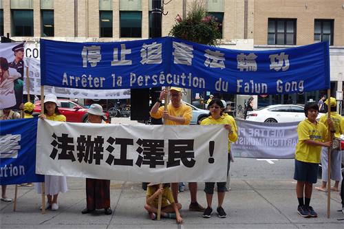 图2:法轮功学员面向蒙特利尔中领馆打出真相横幅,呼吁停止迫害