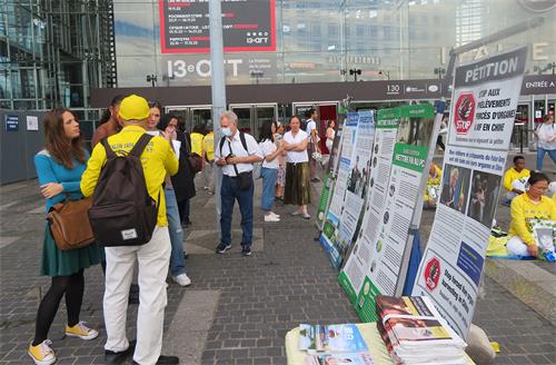 图3~5:人们观看展板,向法轮功学员了解真相。