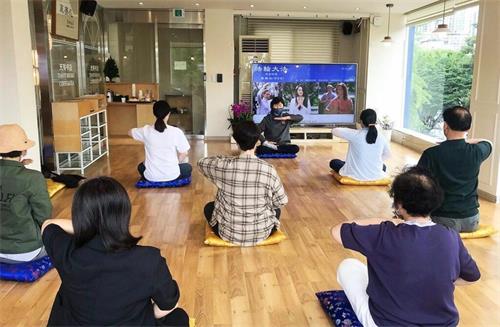 '图1:参加六月份法轮大法九天班(上午班)的新学员们正在学习法轮大法第五套功法--神通加持法。'