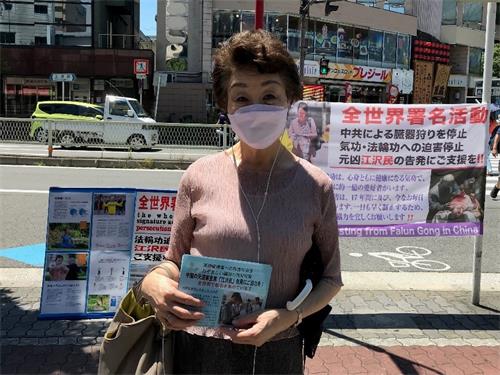 图4:上口女士在真相展板前留影并表示希望更多的人勇敢的站出来发声。