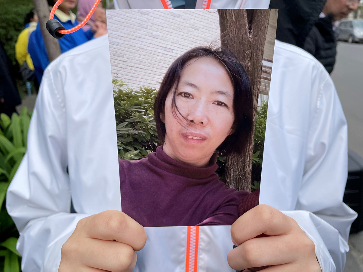 图4:二零二二年八月十五日,姜永芹的大女儿在新闻发布会上手持母亲照片。