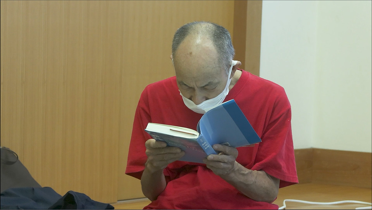 图5:这位男士在认真阅读日文《转法轮》书籍