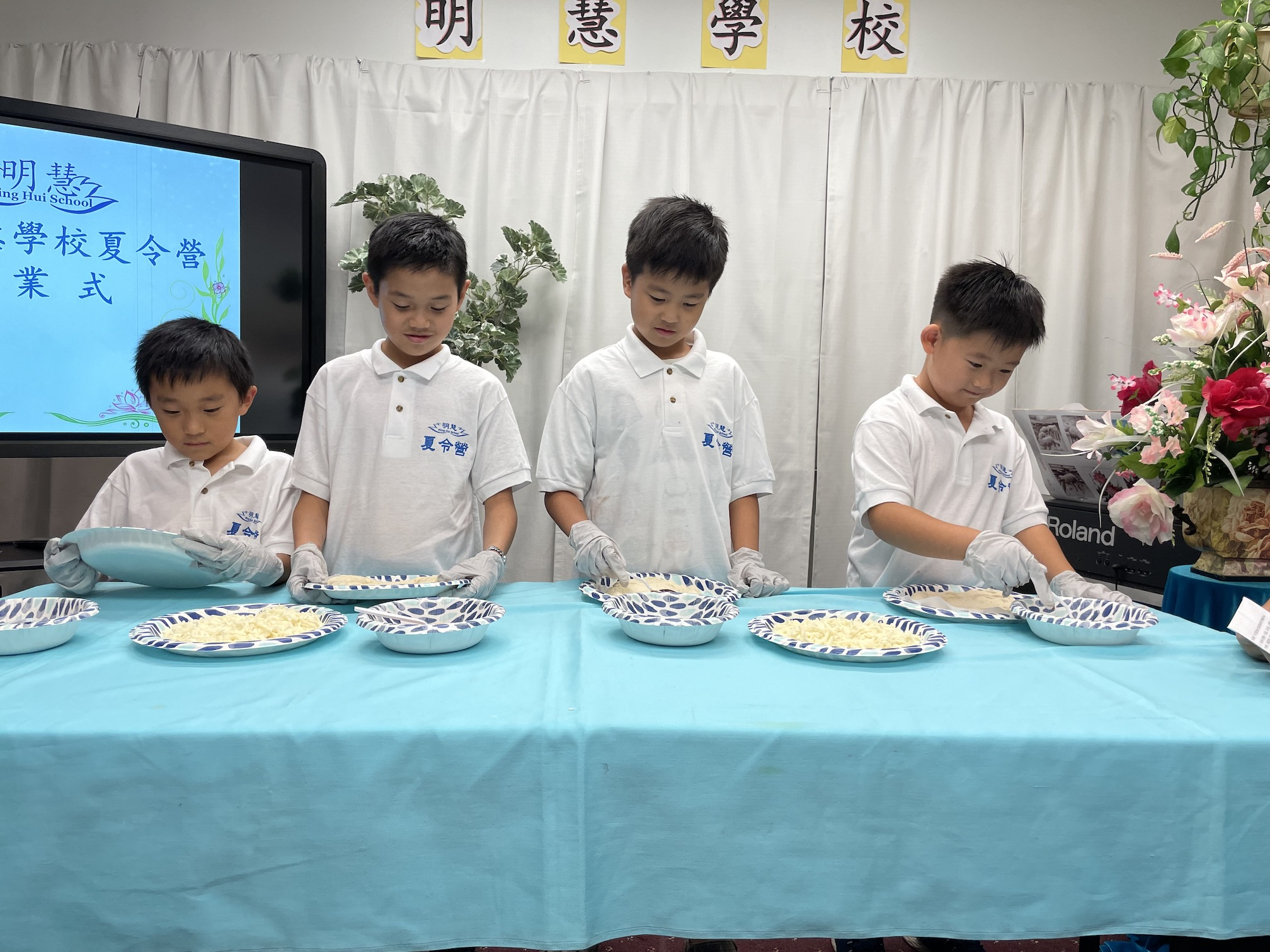图1:明慧夏令营小朋友表演烹饪制作比萨饼