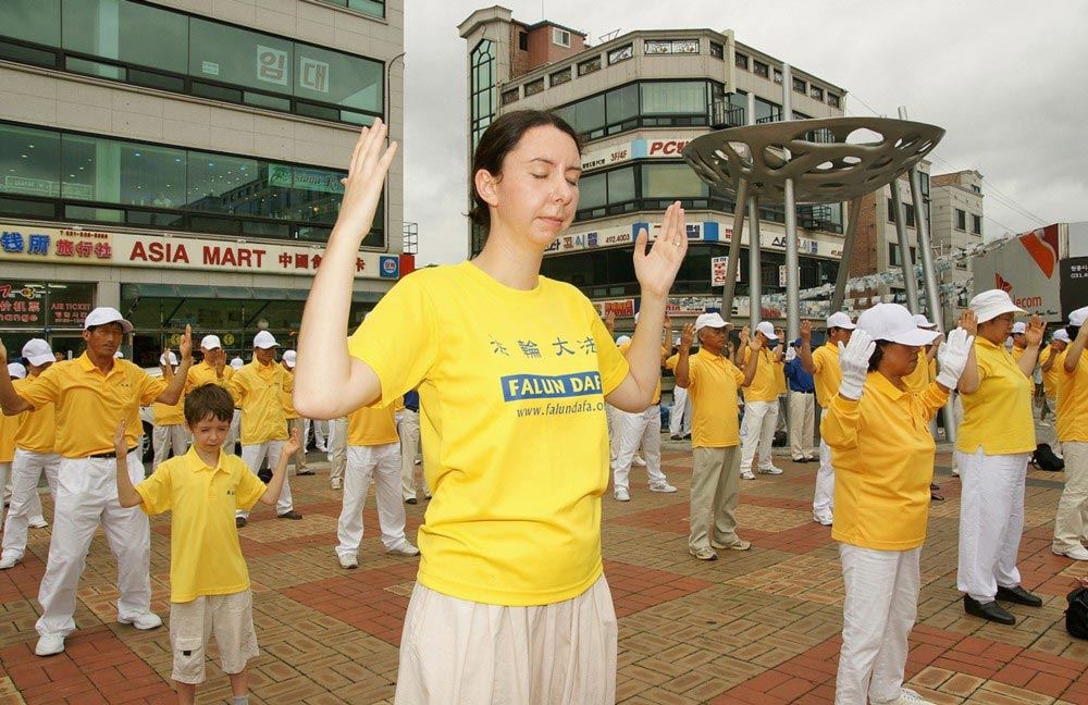 '图5:艾玛和贾洛德在韩国工作期间,全家参加当地的反迫害活动。艾玛身后是他们的儿子。'
