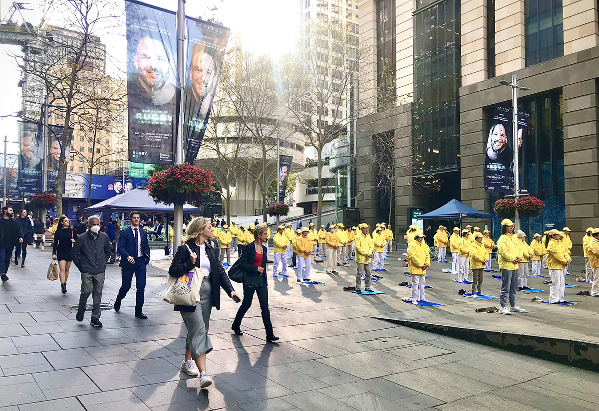 图1~2:二零二二年九月八日,悉尼上班族在晨曦中迎来法轮功学员展示的法轮功第五套功法静坐。