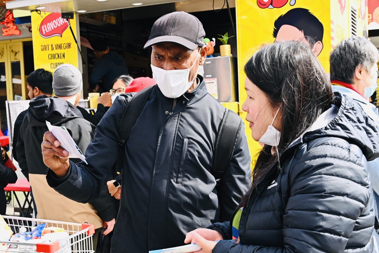 图7:墨尔本教师塔拉萨亚(Thornly Talasaia)在法轮大法摊位前和学员交谈了很长时间。