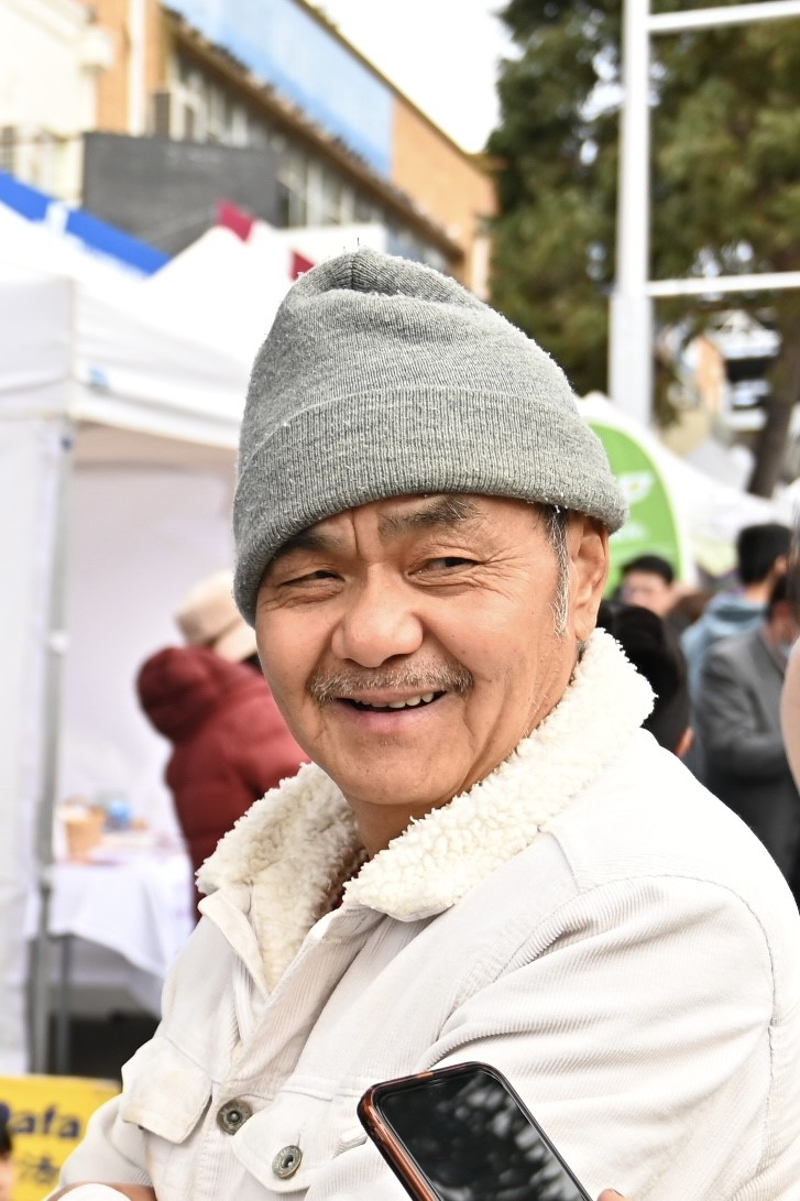 图9:听说过法轮功神奇功效并想了解详情的刘先生,当天看到了法轮功的展位,很开心。