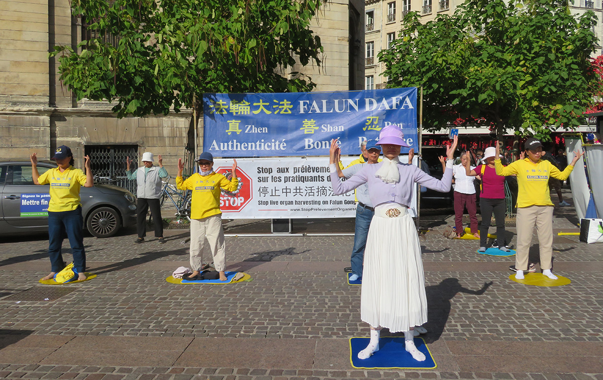 图1:二零二二年九月十七日,在巴黎市中心夏特莱(Châtelet),法轮功学员向人们展示功法。