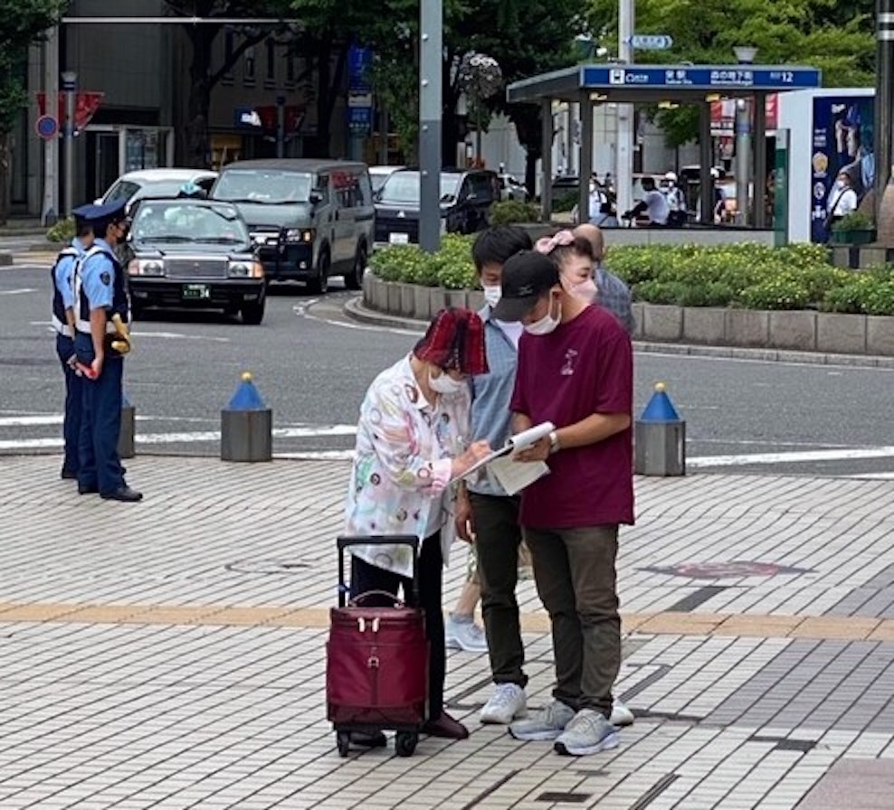 图5~6:二零二二年八月二十七日(星期六)与二十八日(星期日)这两天,在名古屋市(Nagoya-City)最繁华地段—荣(Sakae)的喷水附近,行人明真相后在声援诉江的签名纸上签名时的情景。