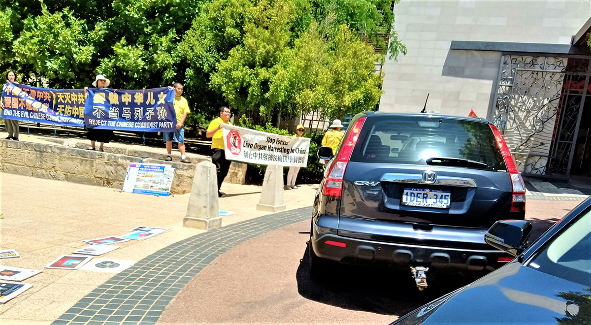 图3:领馆试图用车遮挡法轮功学员的真相横幅