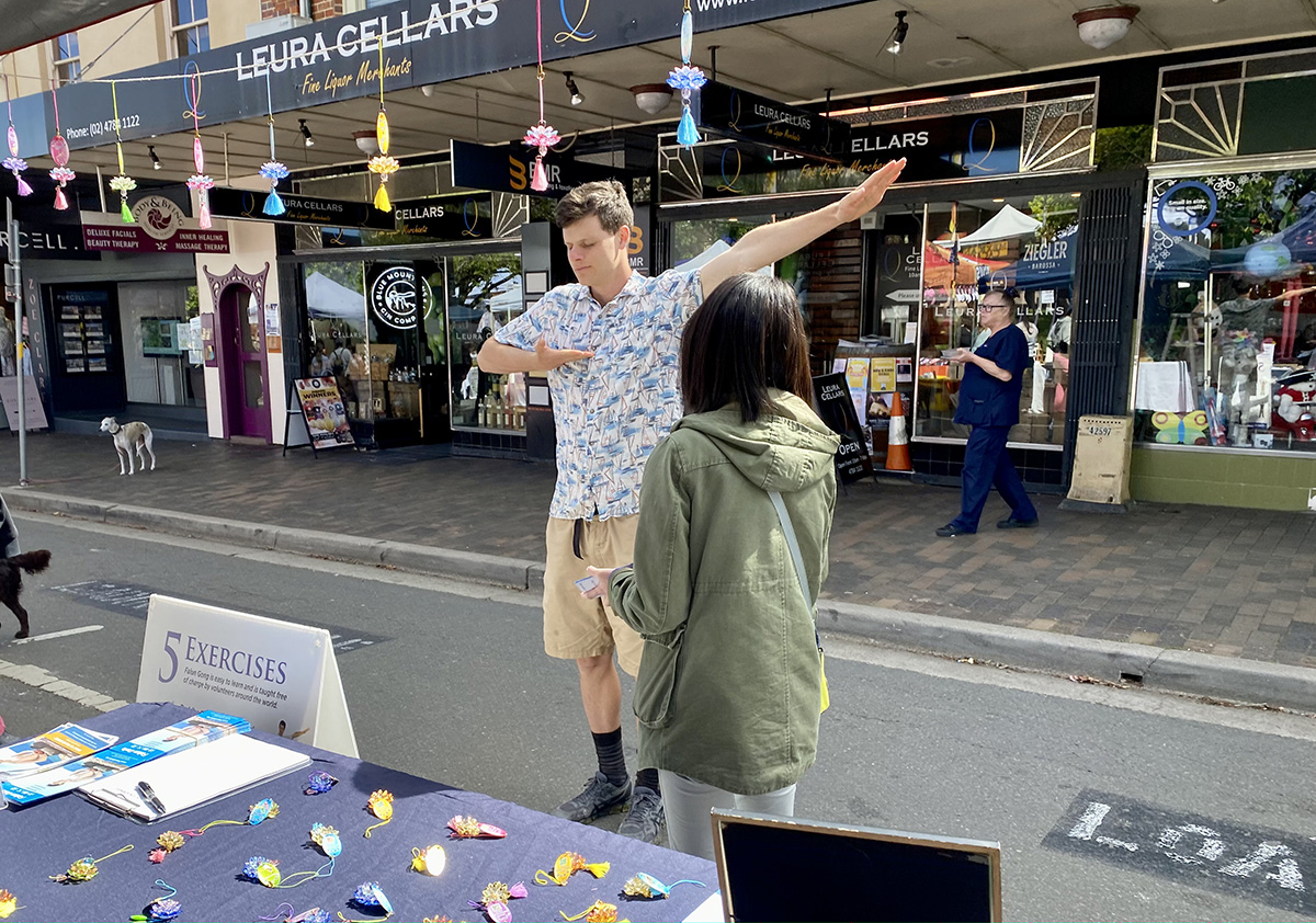 图9:一年轻人很感兴趣,跟着展板学炼动作。