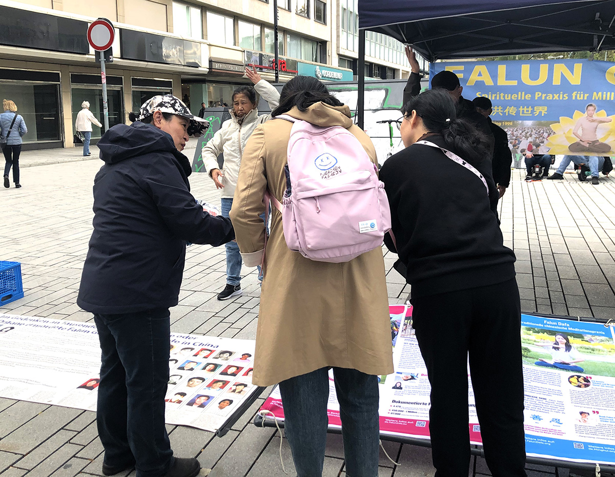 图4:两位中国游客在真相点阅读展板