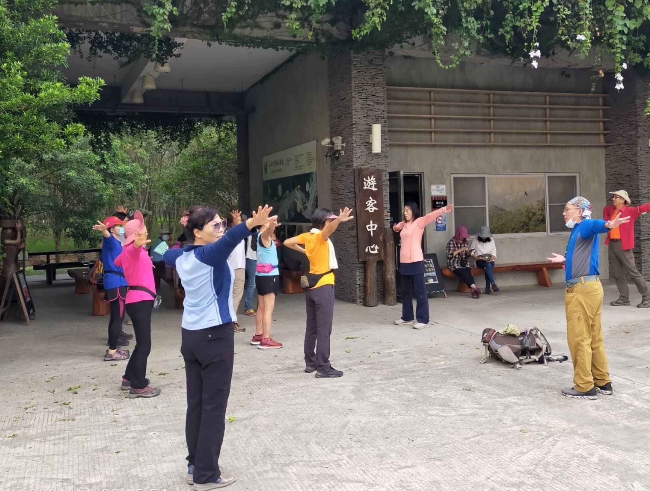 图4:有一次,在登山出游过程中,江霖在游览车上讲述自己僵直性脊椎炎炼法轮功炼好了,众人啧啧称奇,下车後马上让她教功,於是,她教大家学炼了法轮功的第一套功法──佛展千手法