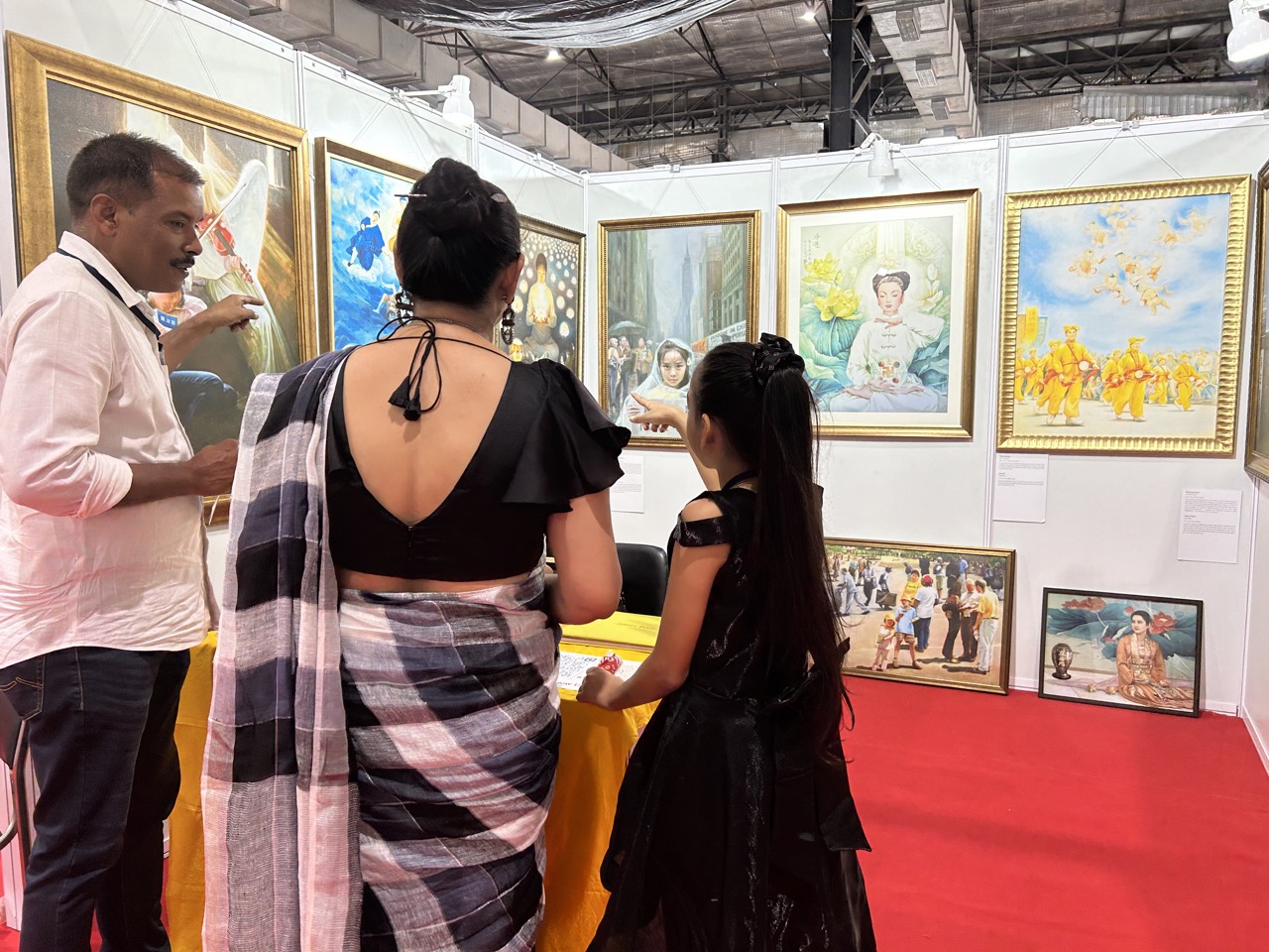 图9:第二天,舒克拉(右)带母亲荷曼丽(中)前来观看真善忍美展。