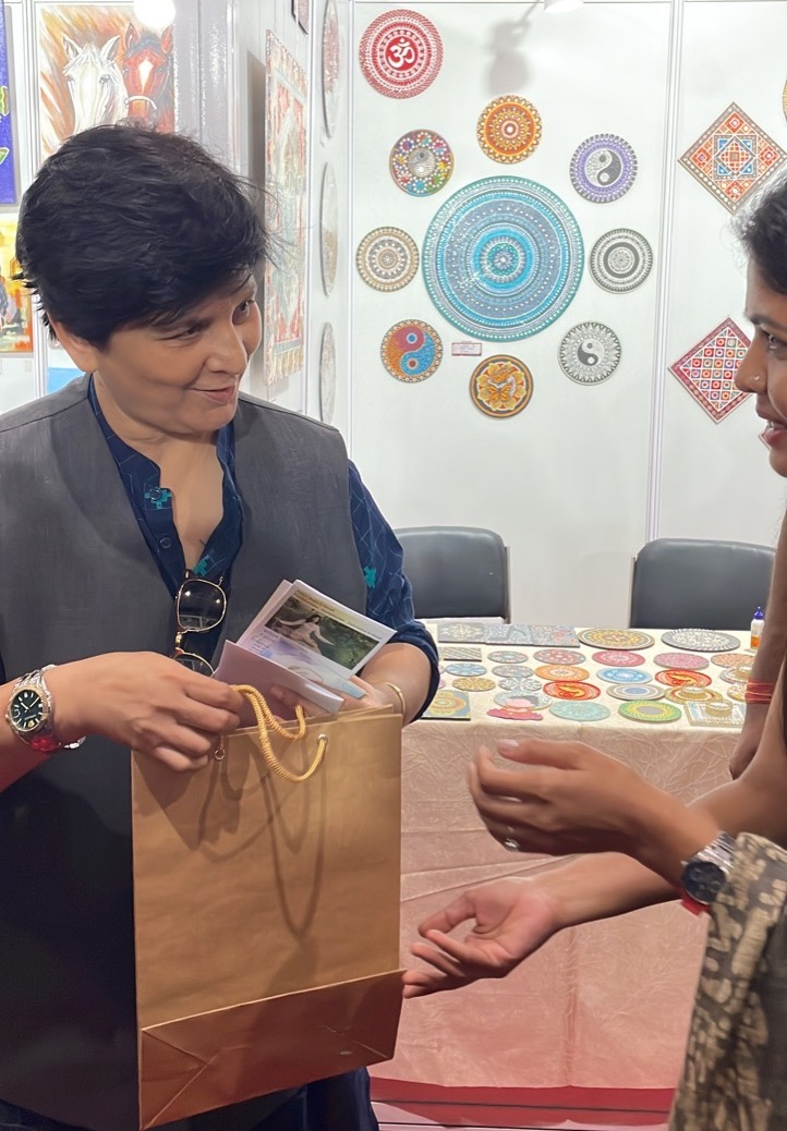 图15:印度著名歌手法尔古尼·帕塔克(Falguni Pathak)听完学员的讲解,拿了法轮功资料阅读。