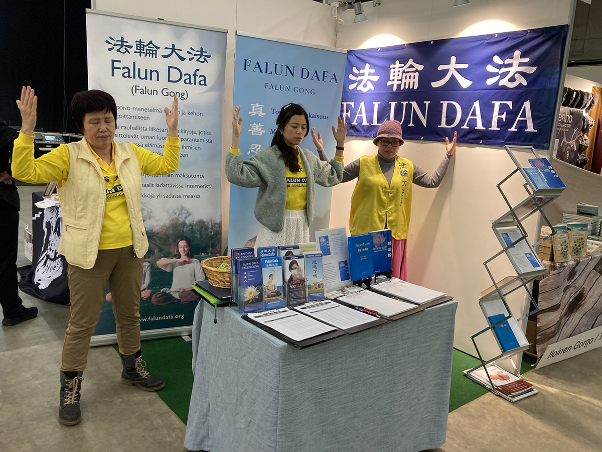 图2:法轮功学员在赫尔辛基书展上设立展位。学员在展位中展示法轮功功法。