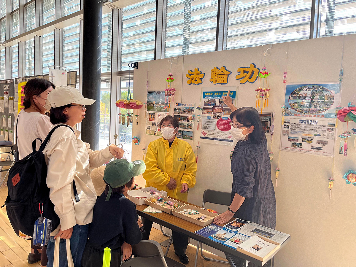 图1:来到展位前的市民在阅读法轮功资料。