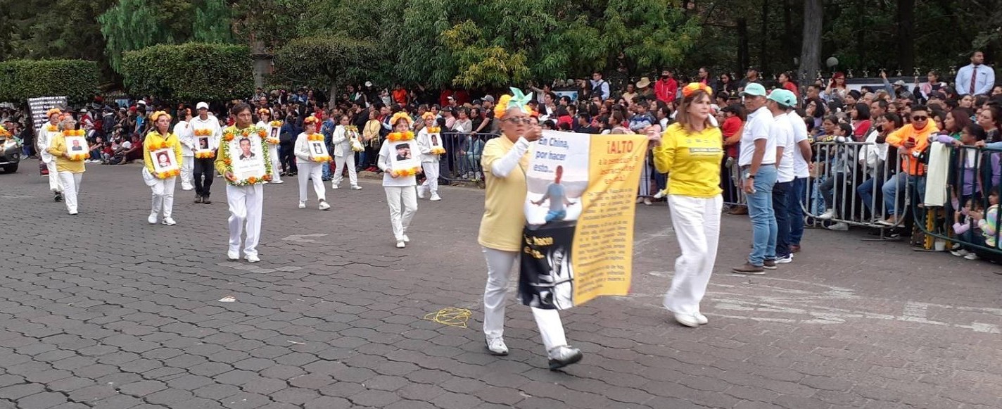 图3:反迫害方阵学员手捧被中共迫害致死学员的照片肃穆行进。