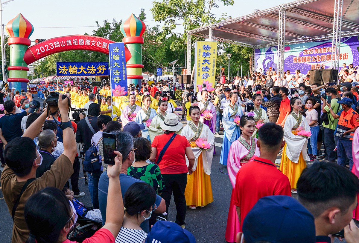 图3:天国乐团后面紧跟着的是吉祥献瑞的法轮功仙女队伍,和祥和的五套功法展示,民众争相拍照。