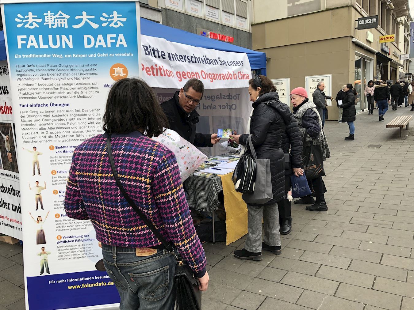 '图4:一位女士在仔细阅读介绍法轮大法的展板。'